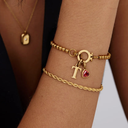 Gepersonaliseerde kralenarmband met geboortesteen en initiaalbedel